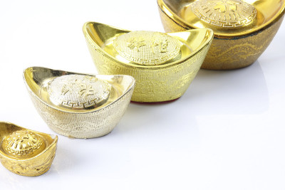 春节喜庆装饰品，金元宝孤立上白。汉字意味着好运、财富和繁荣。