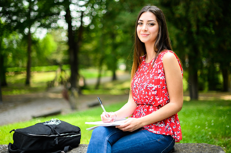 Beautiful female college student reading a book on