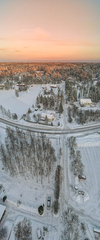 鸟瞰图白色的冬天森林与雪覆盖的树木和农村道路在芬兰