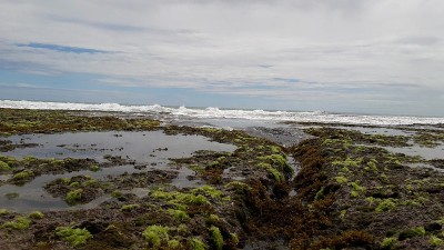 印度尼西亚Sukabumi, Minajaya海滩上的岩石、水和海浪的照片