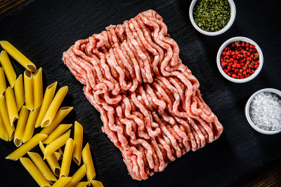 生意大利面，碎肉和调味料的石头背景