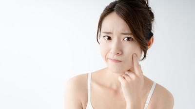 年轻的亚洲女人担心她的皮肤。