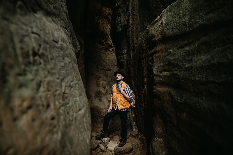 一个孤独的徒步旅行者站在一个山洞里，旅行的概念