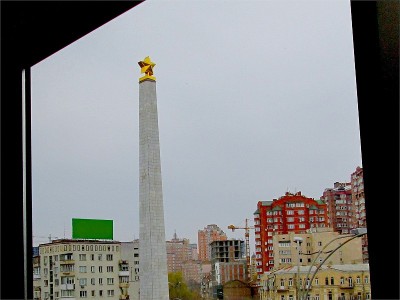 秋天多云胜利纪念碑方尖碑雕像与周围的建筑物窗户视图