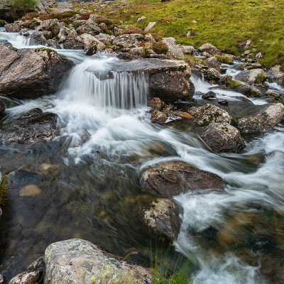 秋天，在斯诺登尼亚的Llyn Ogwen和Llyn Idwal附近，一条河流顺着山脉流下的穆迪景观图