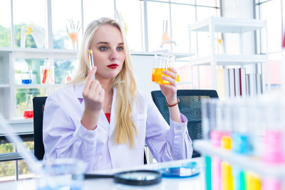 一个女性研究人员在化学实验室里进行研究的科学家拿着试管和样品在实验室分析的背景