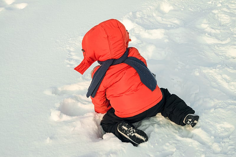 小男孩在冬天散步时跌倒在雪地里