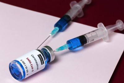 装有COVID-19检测疫苗的透明玻璃瓶和注射器