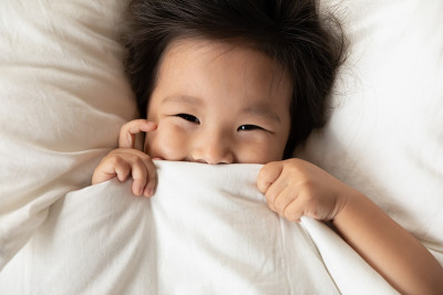 俯视图近距离亚洲小女孩窥视从毯子