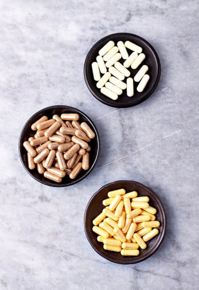 辅酶Q10， α硫辛酸和绿茶胶囊。免疫系统的支持。健康膳食补充的概念。明亮的石头背景。直接上图。副本