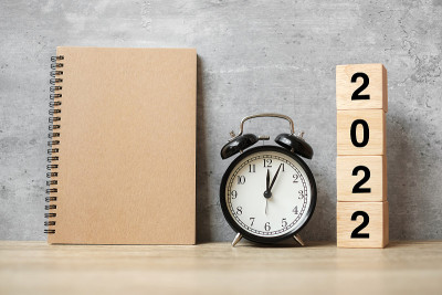 2022年新年快乐与空白笔记本，黑色复古闹钟和木制号码。倒计时，决议，目标，计划，行动和任务概念