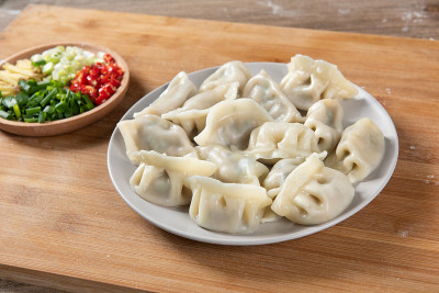 快来看看新鲜的水饺。中国食物在乡村古老的木制背景。