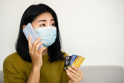 一名亚洲女性致电银行客户，要求因新冠疫情危机延长付款期限