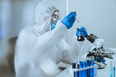 年轻的科学家跌落和摇动生物化学在锥形烧瓶混合和在实验室里看。医生和科学家在covid - 19概念的