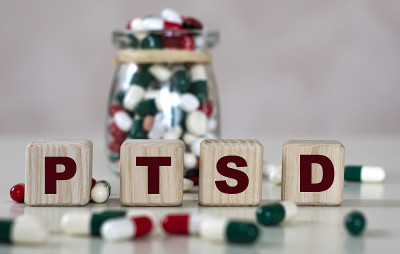 创伤后应激障碍(PTSD)的文字在一个明亮的背景和一罐药片