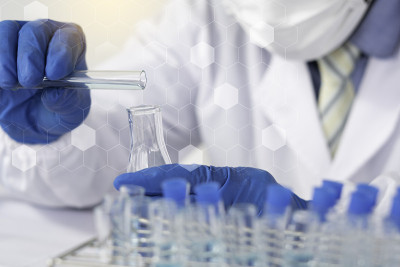 生物化学实验室研究，科学家或医务人员在实验室工作的玻璃设备上，穿着实验室大褂，拿着带有彩色液体的使用