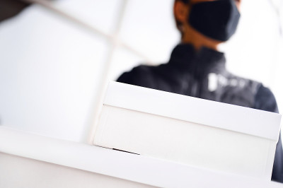 健康保护、安全和流行病概念——孕妇戴着黑色口罩和手套，手持纸板箱在户外接生