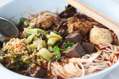 用筷子和勺子盛在白碗里的香辣肉酱米粉。泰国辣的食物。