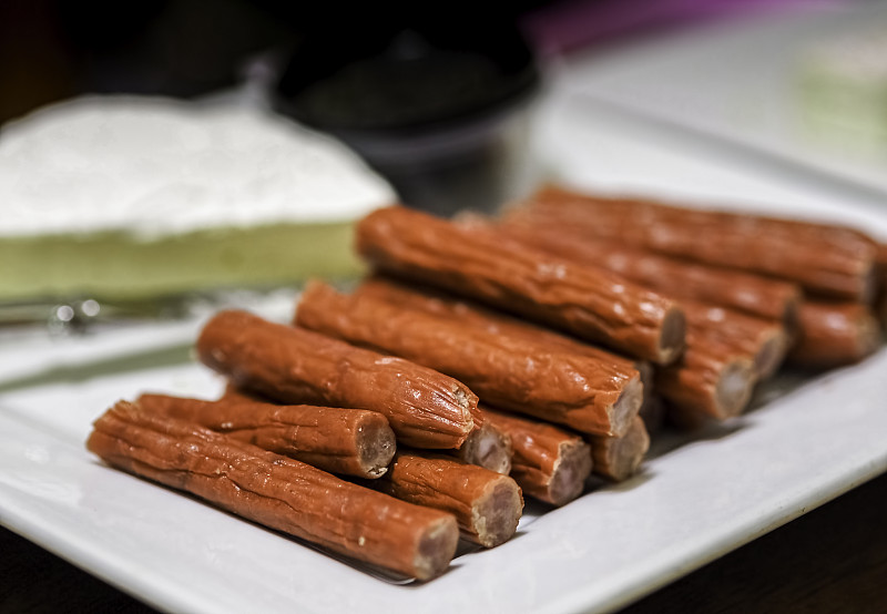 在前景放上腌制的意大利腊肠或肉条(红色)