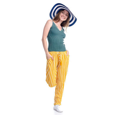 女人戴着夏帽微笑着幸福地走着