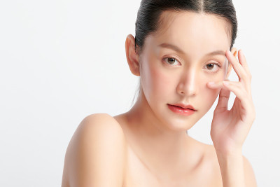 美丽年轻的亚洲女性与干净的新鲜皮肤在白色的背景，面部护理，面部治疗，美容和水疗中心，亚洲女性肖像。