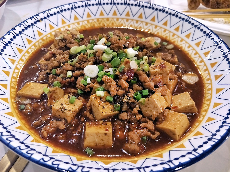 自制的中国当地食物叫麻婆豆腐——用猪肉末和辣椒酱炒豆腐，放在中式盘子里