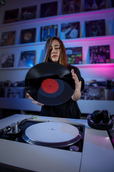 墨西哥dj女孩混合音乐在一个唱片店与转盘和黑胶唱片，复古的概念