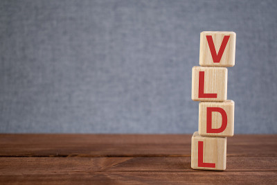 缩写VLDL(非常低密度脂蛋白)文本首字母缩写在木制立方体上在深色木制背景上。医学概念。