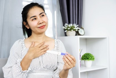 新妈妈高兴地与好消息怀孕测试阳性结果在手