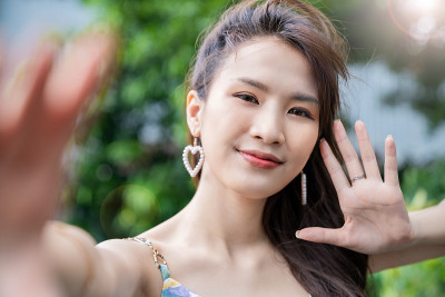 年轻美丽的亚洲女人的肖像使用智能手机自拍说嗨在网上直播。快乐亚洲女孩网红偶像博主。教育技术连接着人们