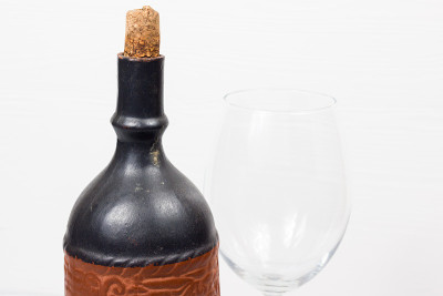 木制背景上的黑酒瓶和玻璃酒杯