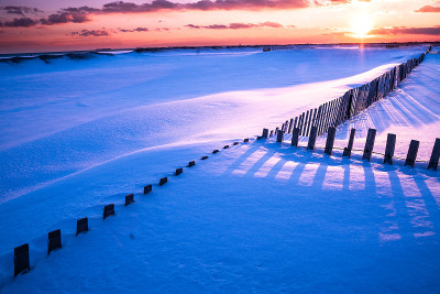 冬季海滩景色与雪在日落