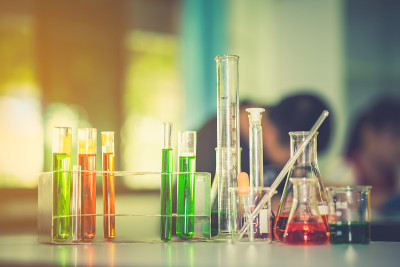 化学实验室桌上的玻璃器皿和教室里模糊的学生