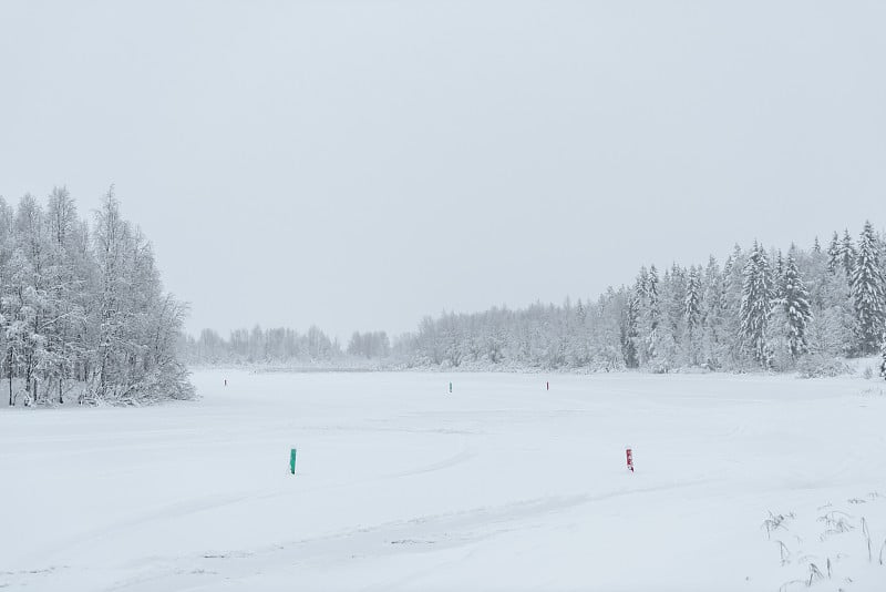 冬季，芬兰库库库鲁度假村的冰湖和森林被大雪覆盖，天气恶劣。