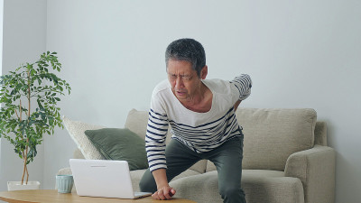 中年亚洲男子腰痛。