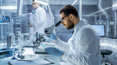 在一个现代实验室研究科学家在显微镜下检查物质。