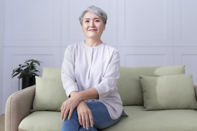 客厅里坐在沙发上的快乐老妇人的肖像