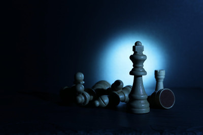 木雕象棋人物在黑暗和戏剧性的灯光下