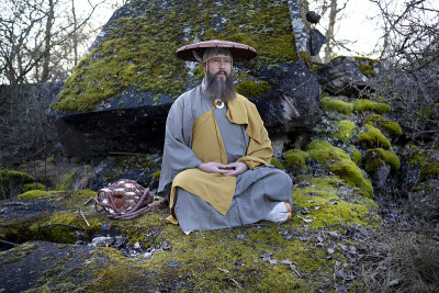 蓄着胡须的欧洲男人穿着传统的日本修道服装进行冥想