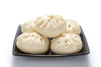 新鲜的包子(中国馒头)装在黑色陶瓷盘子里
