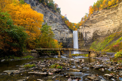 Taughannock瀑布峡谷与人行桥溪日出在全秋天的颜色在雾天