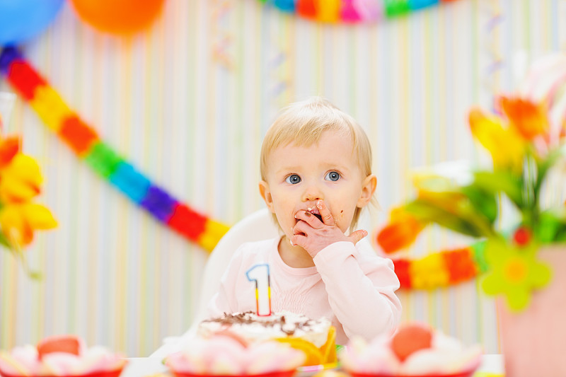 孩子在吃第一个生日蛋糕