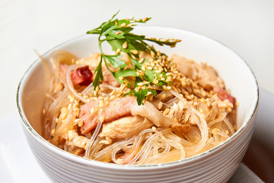 玻璃纸面条与鸡肉和培根在一个轻盘子