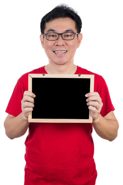 快乐的亚洲华人穿着红衬衫拿着黑板