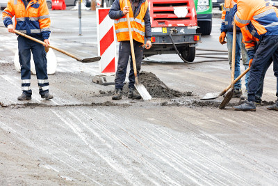 道路工人正在清理车道上用篱笆围起来的路段。