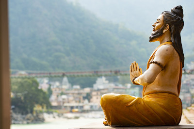 恒河河岸上的印度教雕像令人叹为观止。模糊的Lakshman Jhula桥在背景。北阿坎德邦圣地,印度