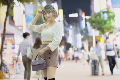 一名年轻女子晚上在东京摆造型