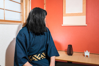 传统的日本推纸门窗，穿着和服的黑头发的男人坐在壁龛旁挂着纸卷轴