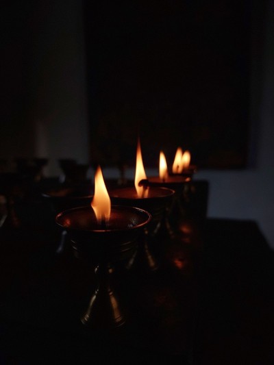 寺庙和修道院的宗教黄油灯节上的佛教祭坛蜡烛。金属器皿内的油灯和摇曳的祈祷火焰，美丽宁静的风景