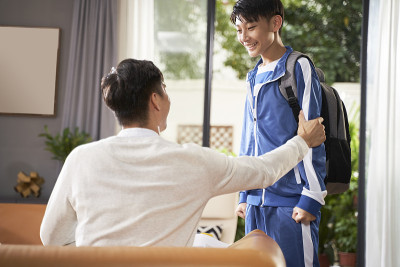 亚洲父亲在儿子回家后祝贺和鼓励他